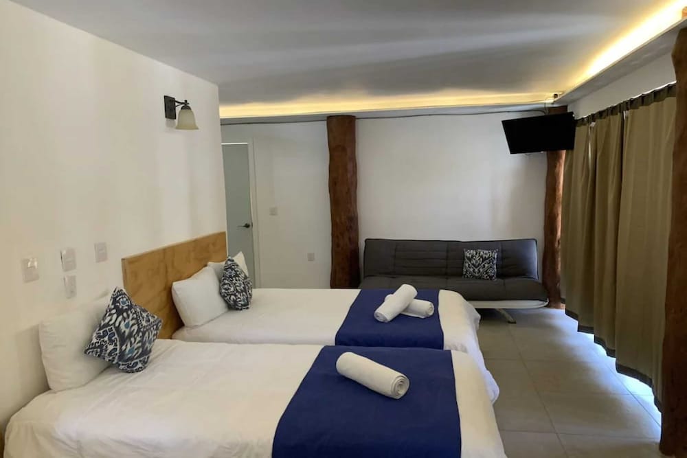 Habitación con televisor y balcón del Hotel & Beach Club Ojo de Agua