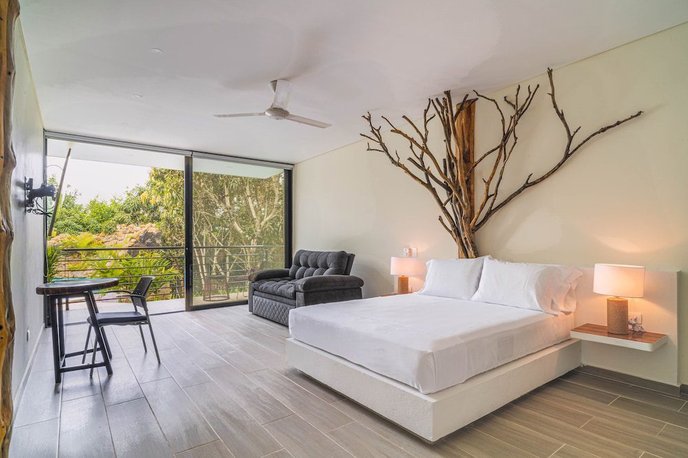 Habitación con cama king y vista al jardín de Natura Lake