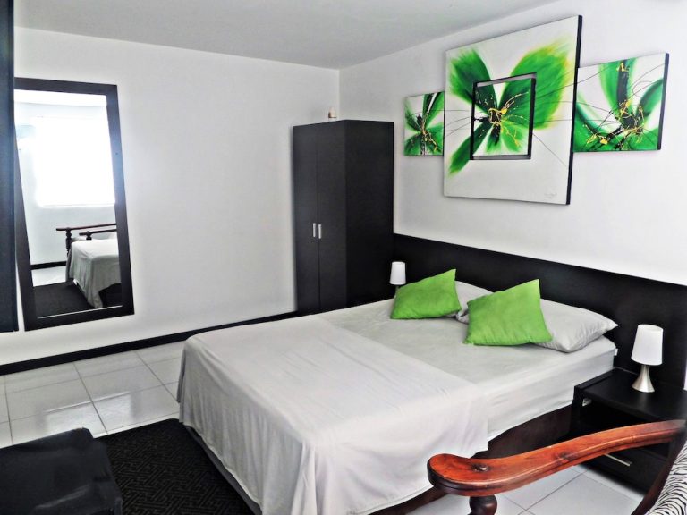 Habitación doble con cojines verdes del Apartasuites San Marcos