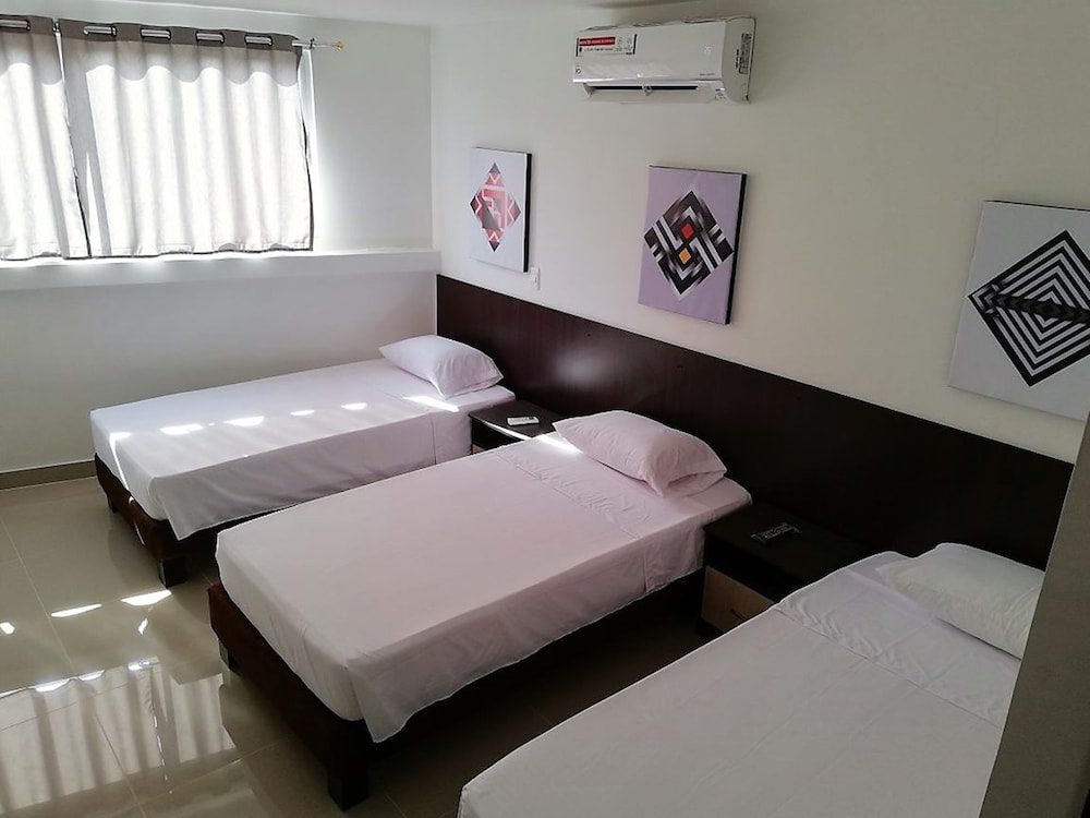 Habitación con tres camas individuales del Apartasuites San Marcos