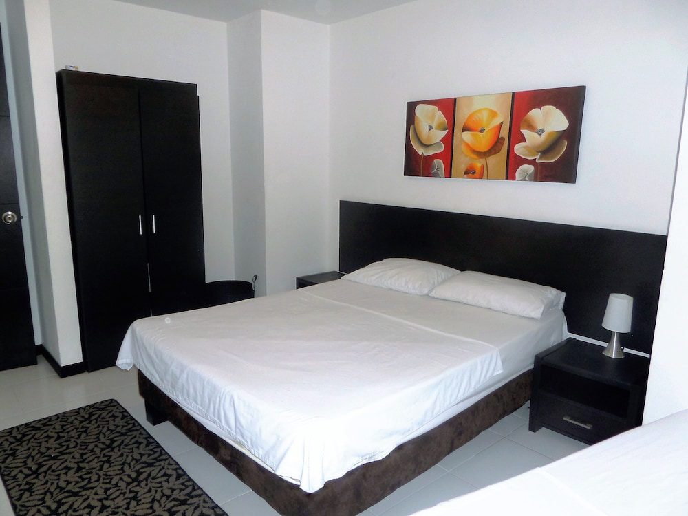 Habitación con cama doble y armario del Apartasuites San Marcos