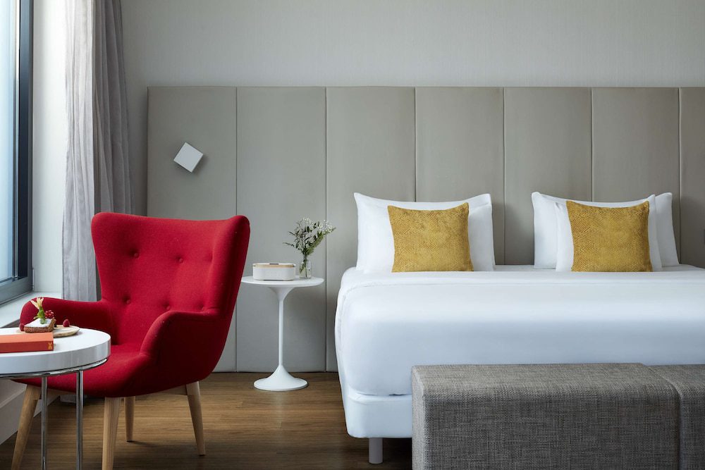 Habitación doble con sillón rojo del Avani Frankfurt City Hotel