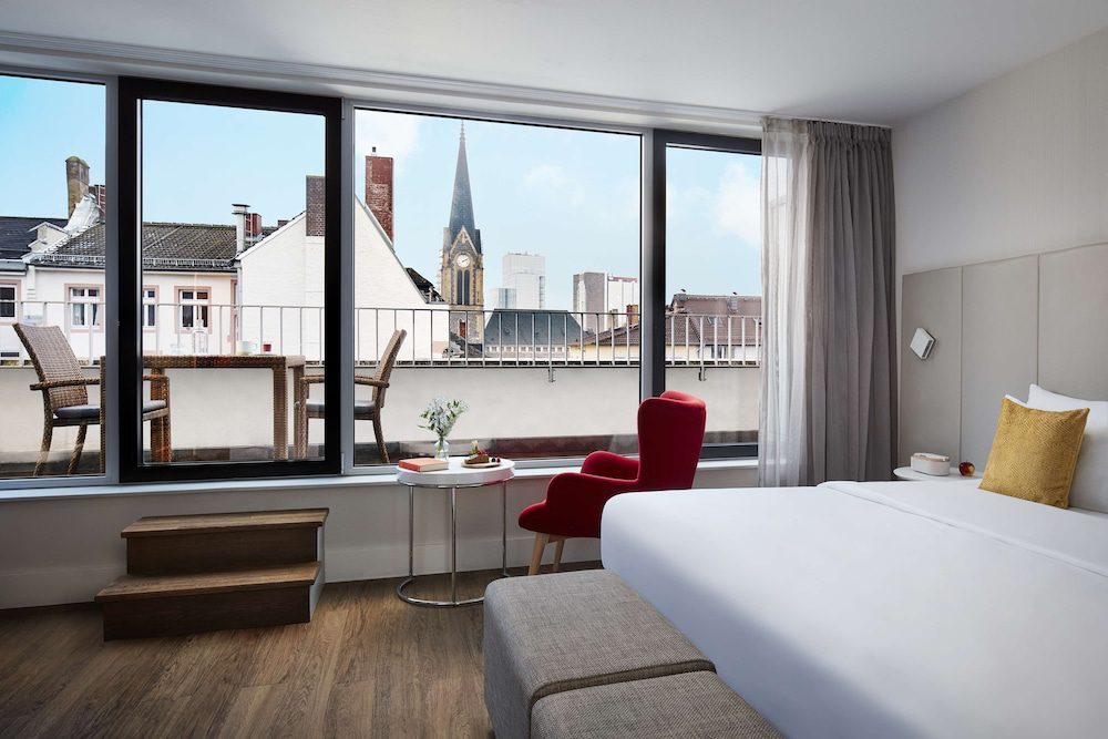 Habitación con ventanal y terraza del Avani Frankfurt City Hotel