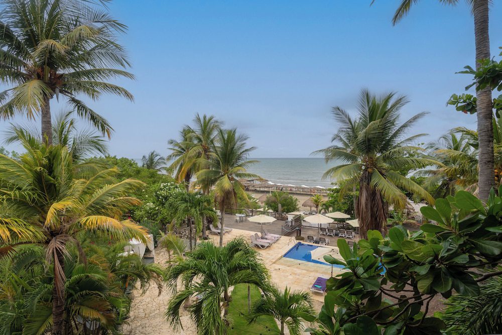 Grand Sirenis Cartagena en Cartagena: vista a la playa y a la piscina entre palmeras