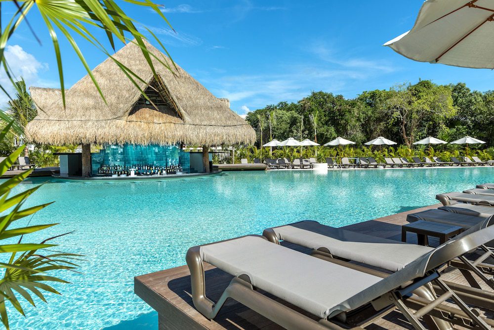 Piscina con camastros de El Beso Adults Only at Ocean Riviera Paradise en Playa del Carmen