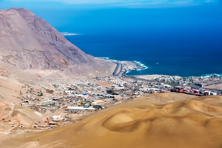 Ciudad costera entre dunas de arena y el océano Pacífico en el norte de Chile
