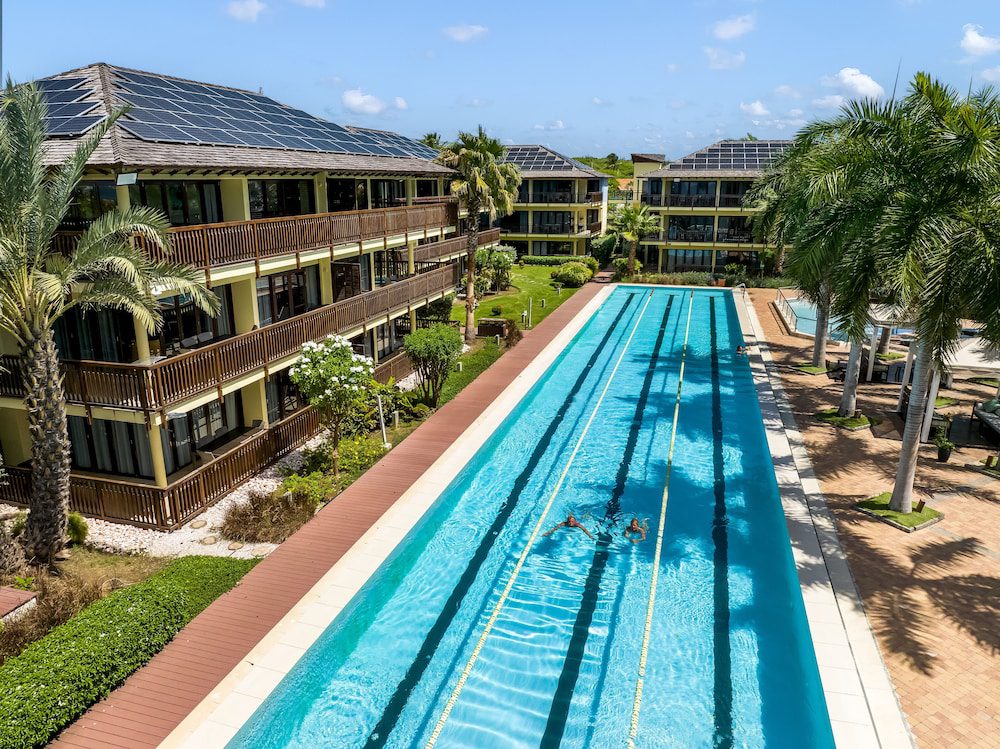 LionsDive Beach Resort en Curazao: piscina larga rodeada de jardines