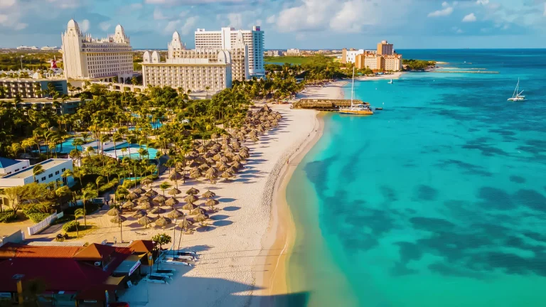 Playa caribeña de arena blanca con palmeras y hoteles, ambiente similar a Isla de Margarita, Venezuela
