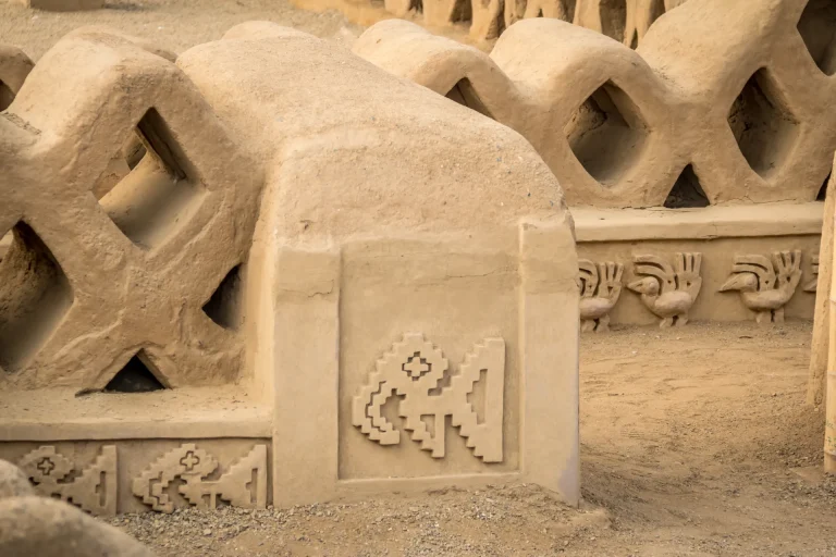 Muros de adobe con relieves de aves y peces en la ciudadela chimú de Chan Chan, Trujillo, Perú