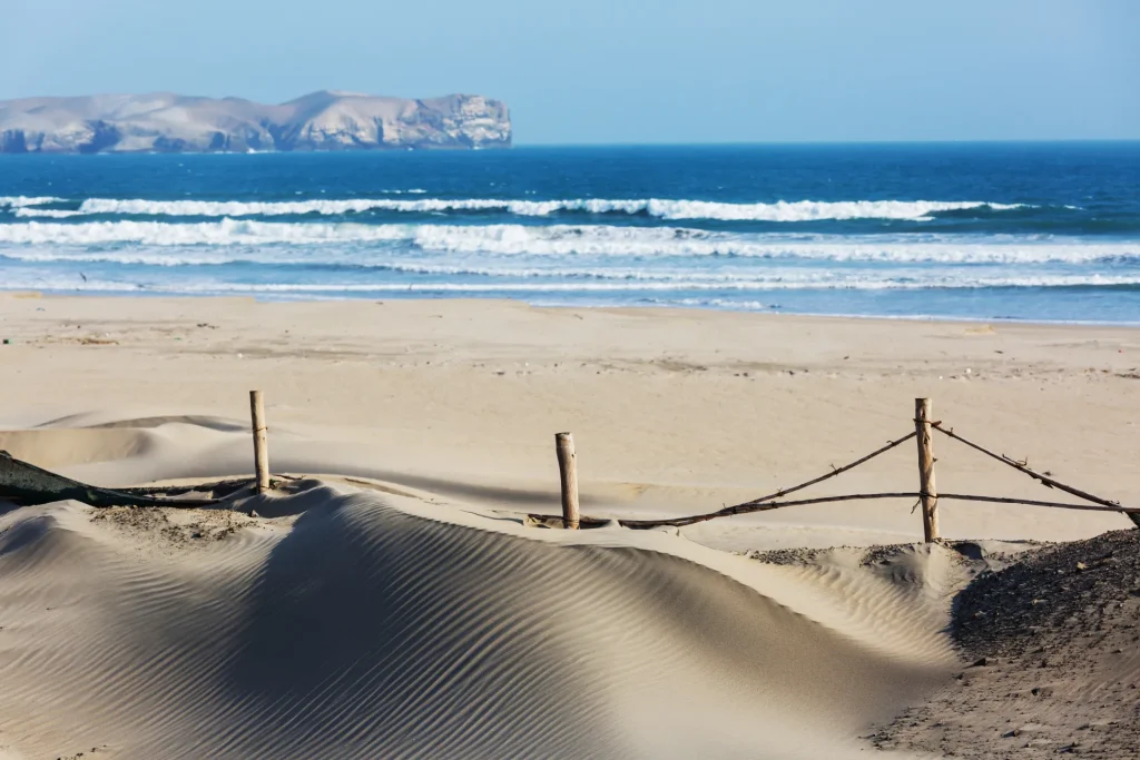 Playa de arena con oleaje en la costa del Pacífico peruano, similar a las playas de Máncora, Piura