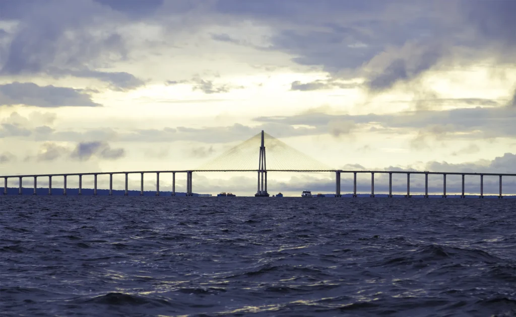 Largo puente atirantado sobre aguas abiertas al atardecer, imagen evocadora del puente sobre el Lago de Maracaibo, Venezuela