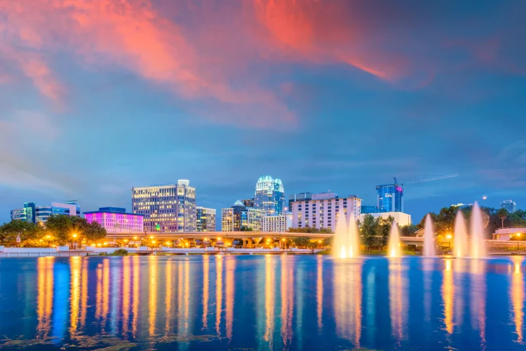 Horizonte de Orlando al anochecer reflejado en el lago Eola con fuentes, Florida, Estados Unidos