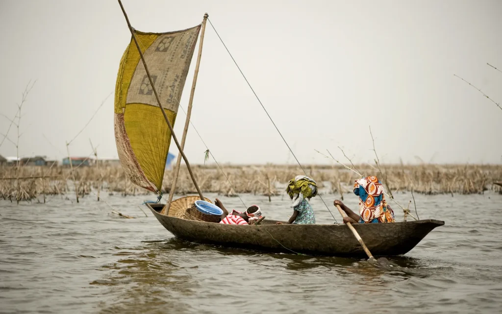 Piragua a vela tradicional navegando en una laguna de África occidental