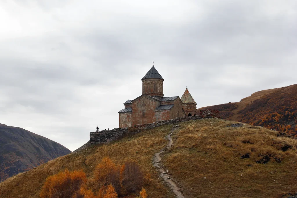 Iglesia de la Trinidad de Gergeti en las montañas del Cáucaso en otoño, Georgia