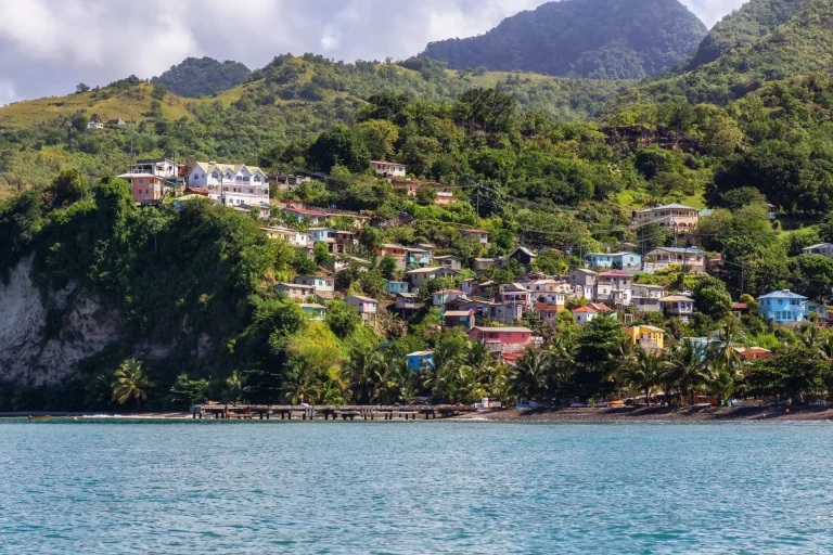 Pueblo costero de casas de colores entre colinas verdes en las islas de Barlovento del Caribe