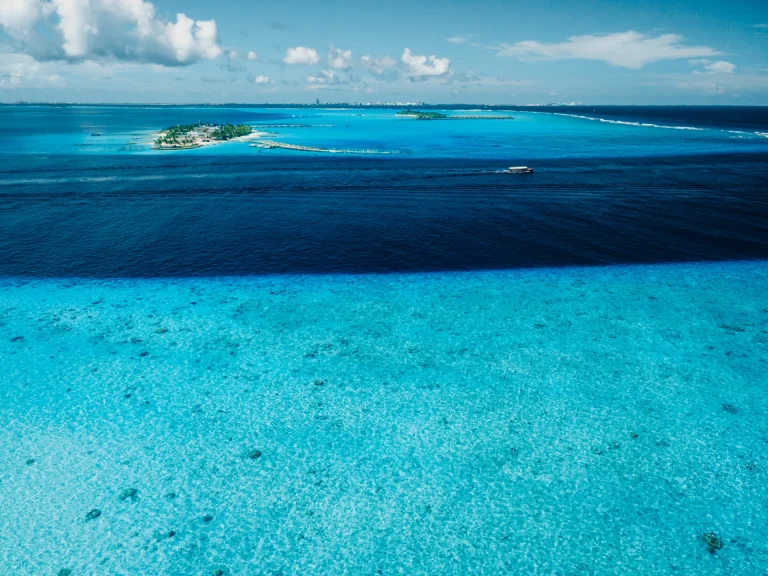 Vista aérea de un atolón de coral con islotes y aguas turquesas