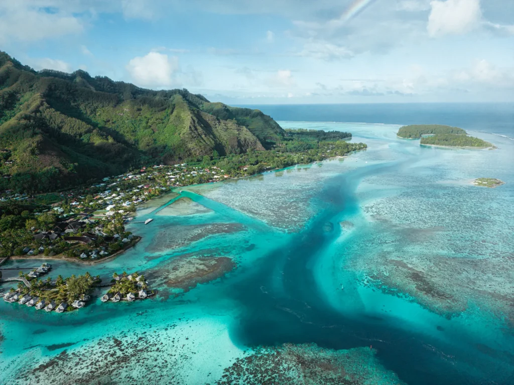 Vista aérea de una isla volcánica con laguna turquesa en la Polinesia