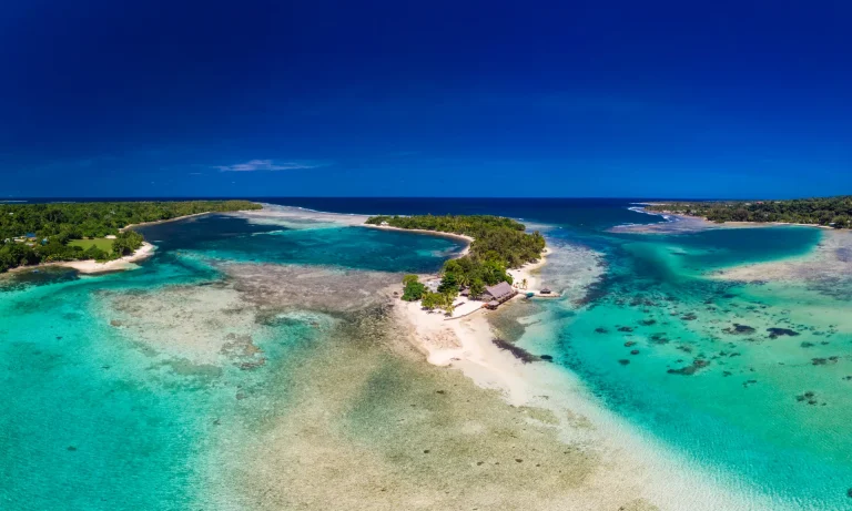 Vista aérea de un islote con laguna turquesa y arrecife en la Melanesia