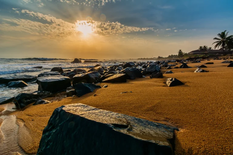 Playa con rocas negras al atardecer en Congo Town, Monrovia, Liberia