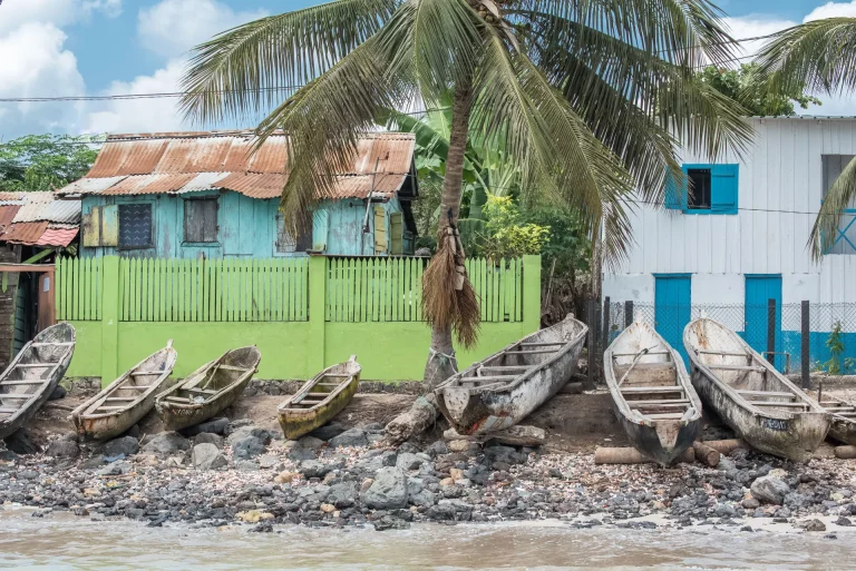 Canoas de pesca frente a casas de colores en la costa de Santo Tomé, Santo Tomé y Príncipe