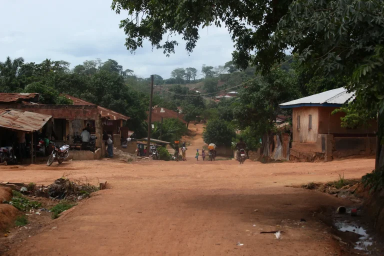 Calle de tierra y casas del pueblo de Kabala entre vegetación, Sierra Leona