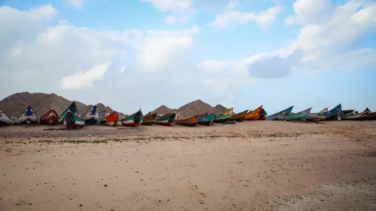 Barcas de pesca de colores en una playa árida del Cuerno de África