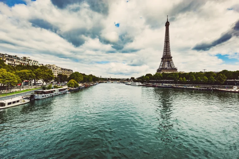 Torre Eiffel junto al río Sena con barcos en la orilla, París, Francia