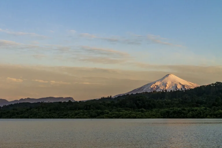 Volcán Villarrica nevado visto desde el lago al amanecer, cerca de Pucón, Chile