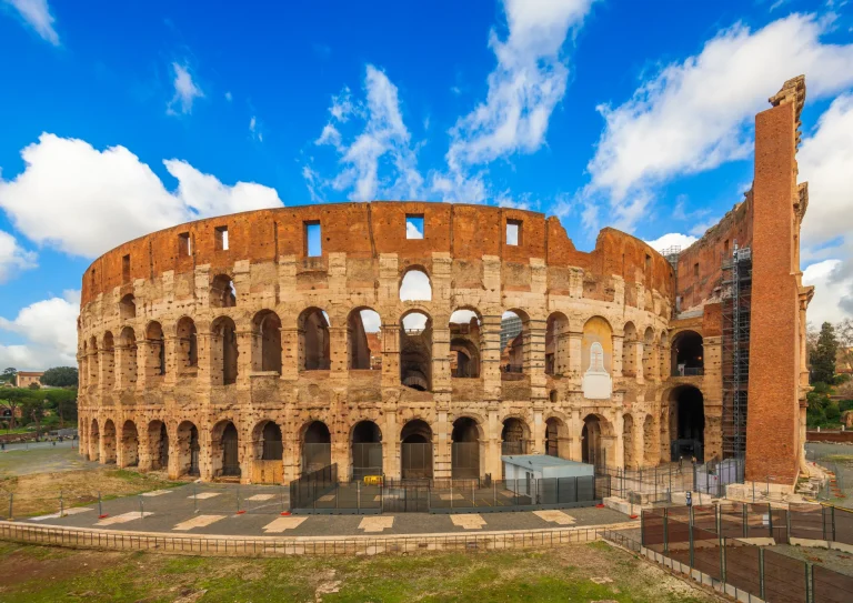El Coliseo de Roma bajo cielo azul, Italia